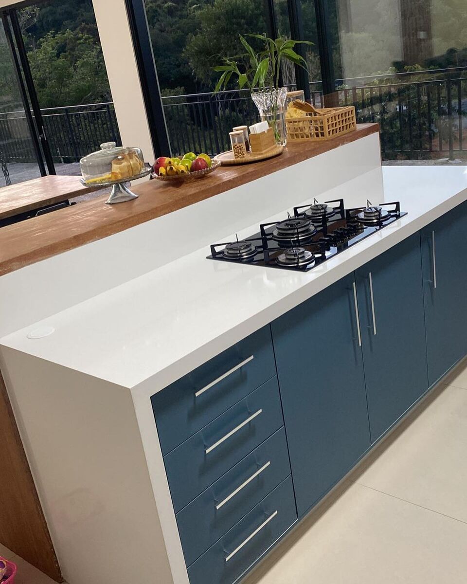 Cozinha com bancada clara e marcenaria azul