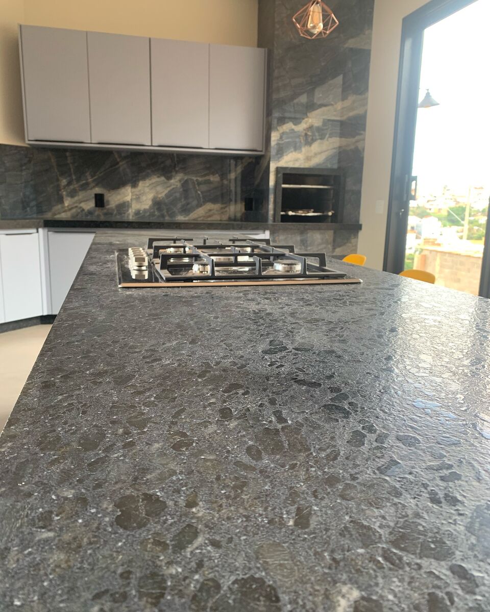 Bancada de cozinha em pedra natural com cooktop embutido