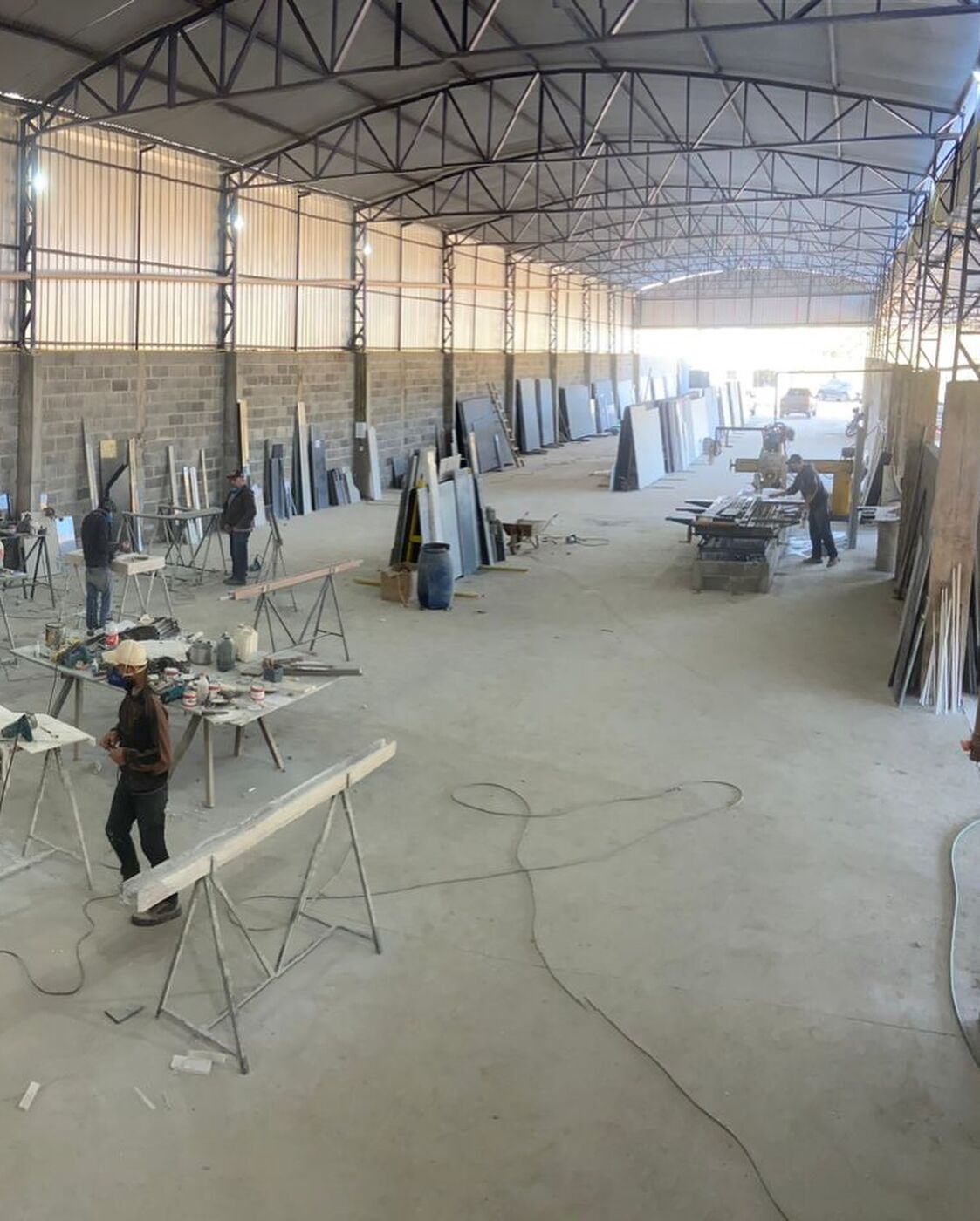 Interior da fábrica da Art Pedras com chapas e bancadas de trabalho